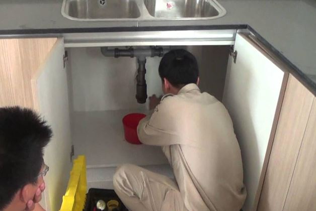 Kỹ thuật viên FixCleanCare đang thông tắc chậu rửa bát cho khách hàng ở Hà Đông